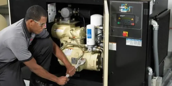 Industrial air compressor repair technician fixing compressor unit